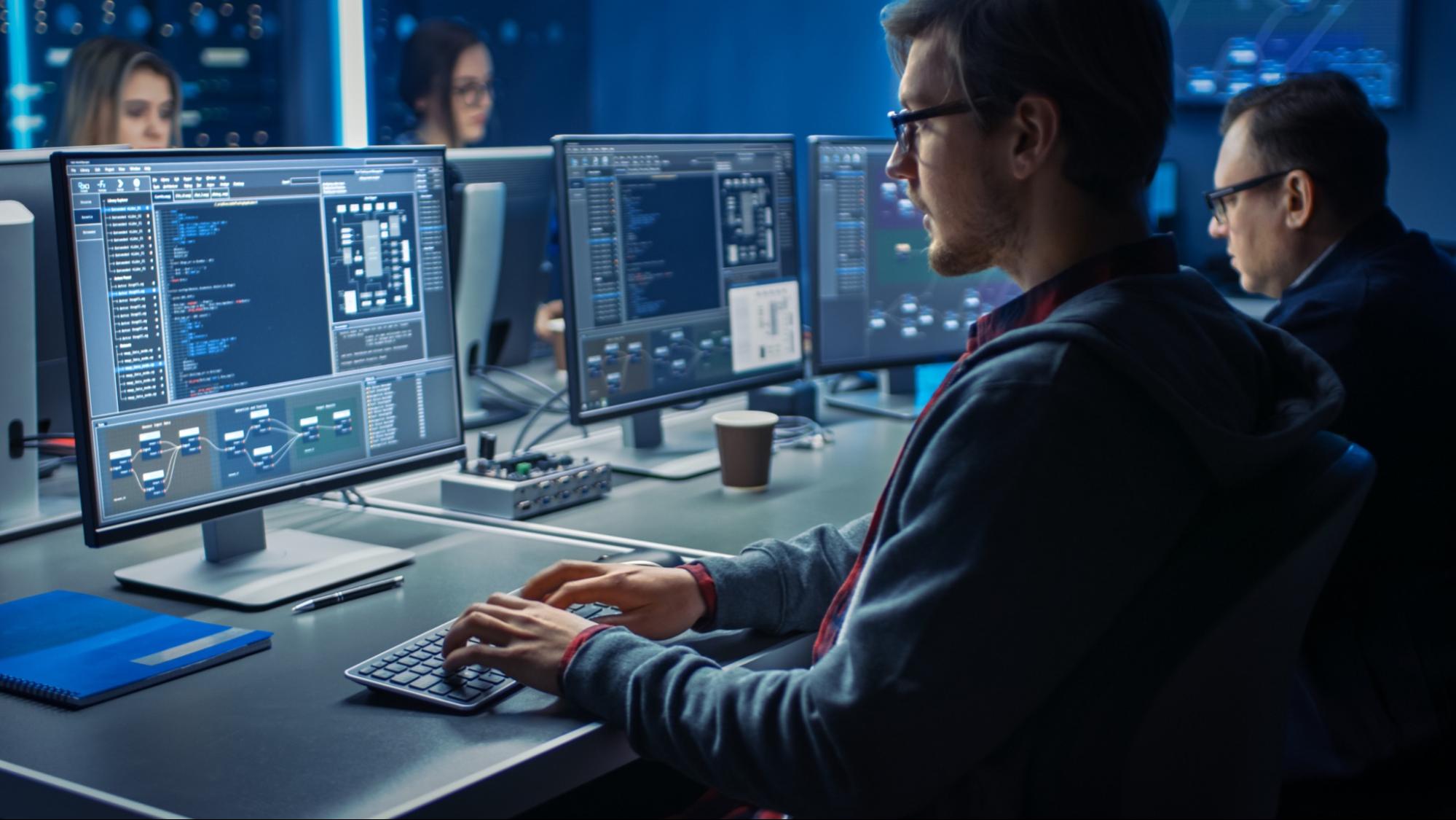 A picture of a IT professional coding at a computer.